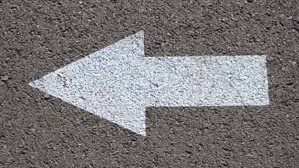 A painted arrow marked on a road surface, its shape filling the frame