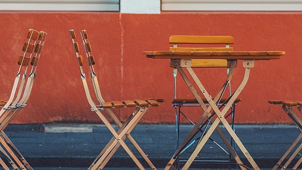 A plain table with chairs set around it, every one of them unoccupied