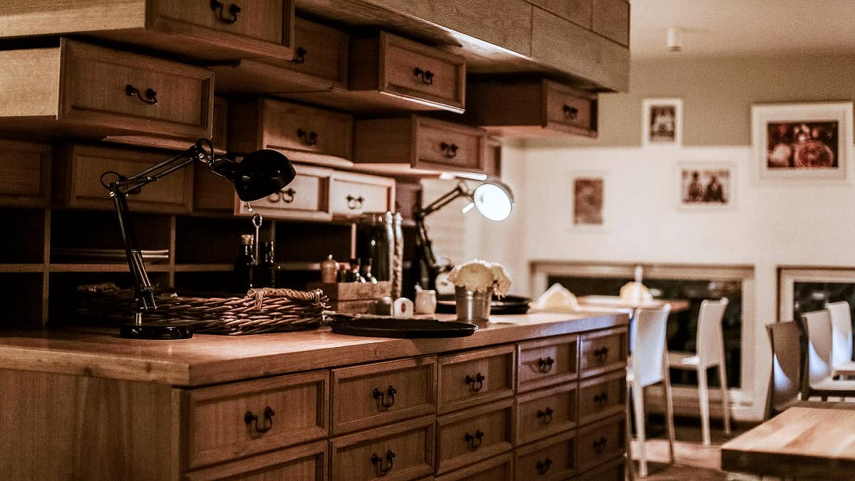 A wooden work counter fitted with rows of small drawers in a warm lit interior