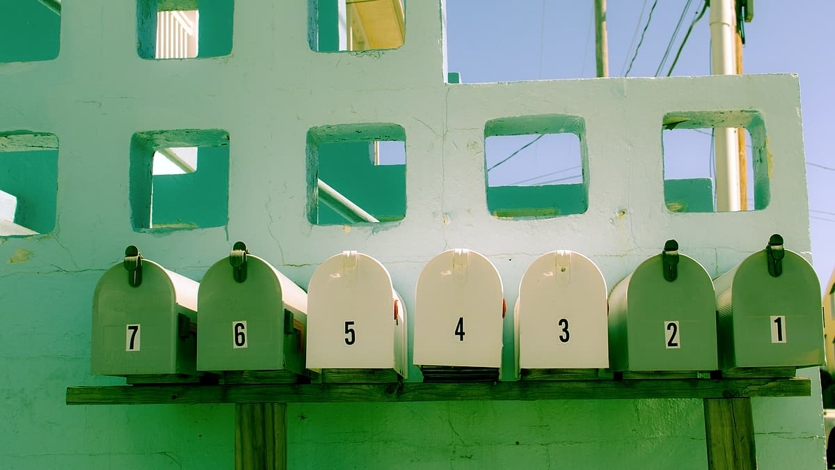 A bank of numbered residential mailboxes fixed side by side to an exterior wall
