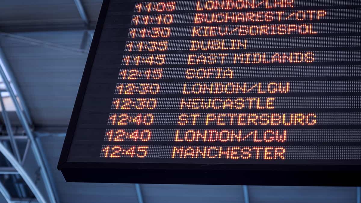 An airport arrivals and departures board showing rows of listed times and destinations