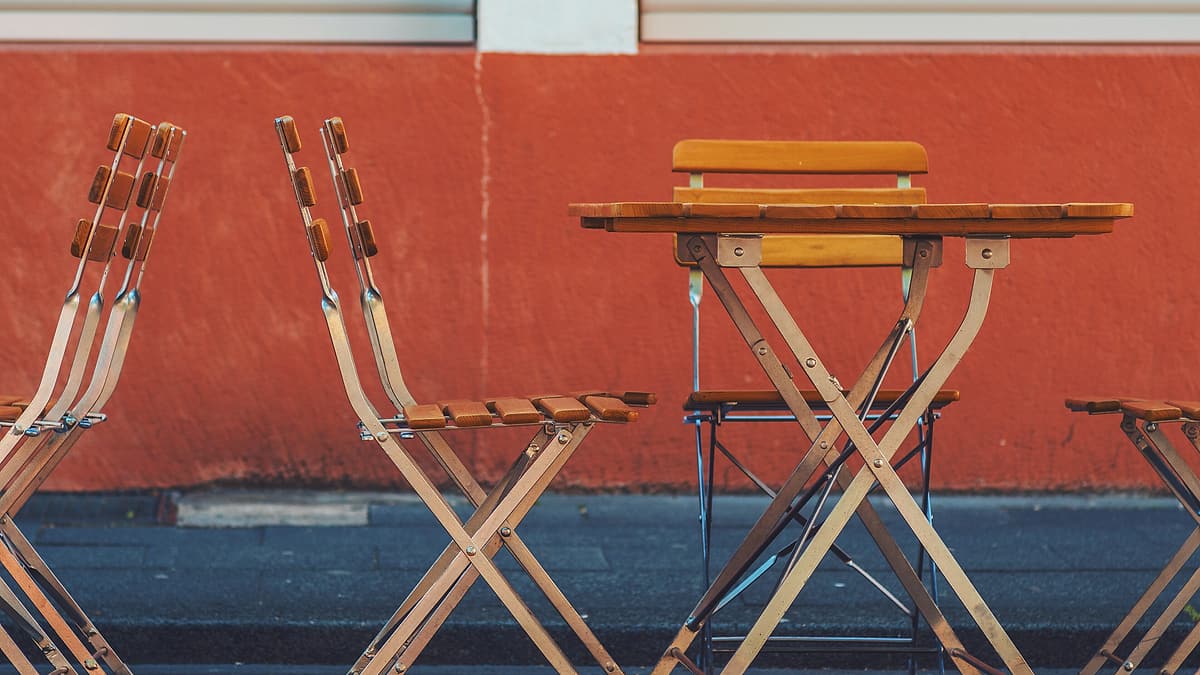 A plain table with chairs set around it, every one of them unoccupied